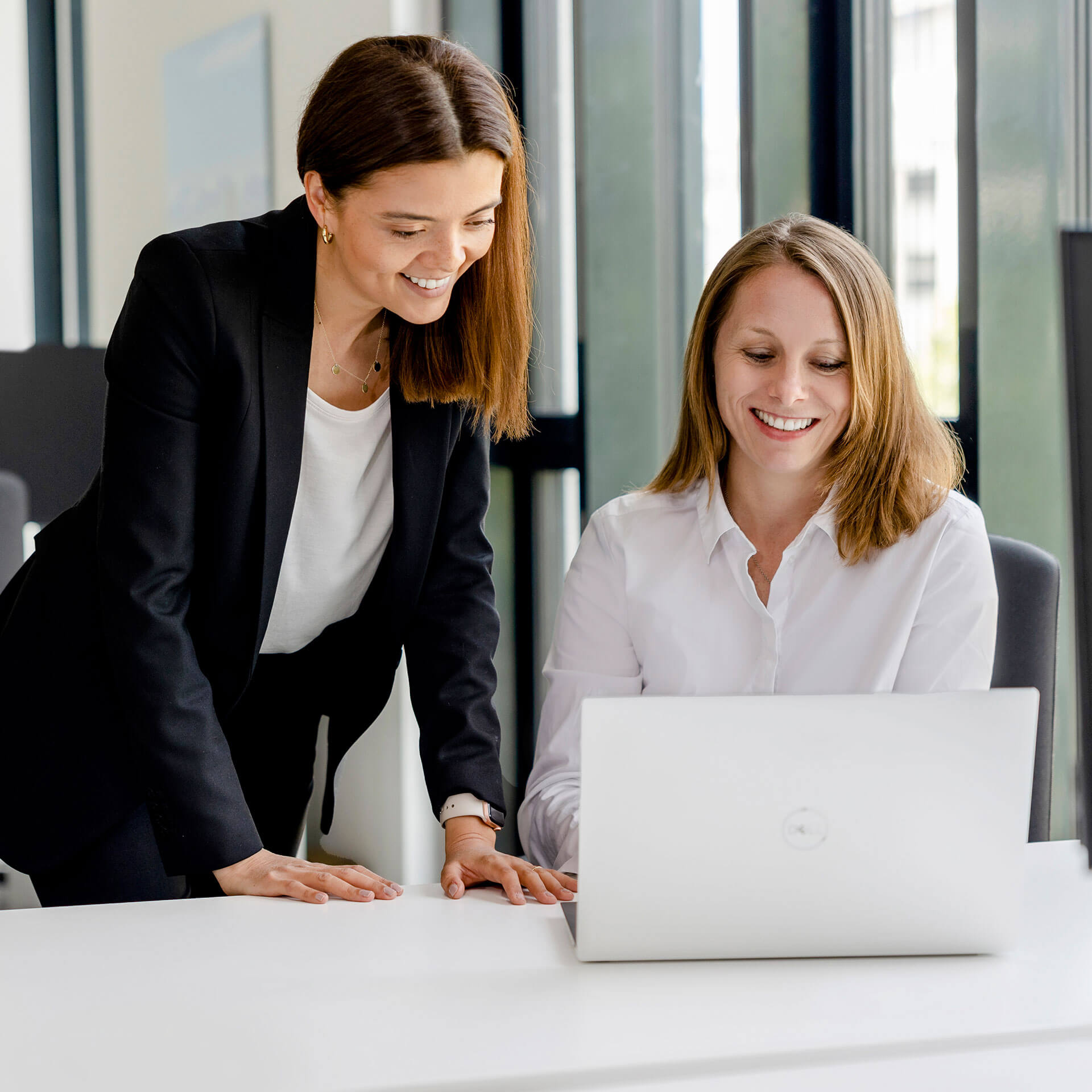 Zwei Mitarbeiterinnen von activeMind betrachten auf dem Laptop den Erfolg eines Kunden